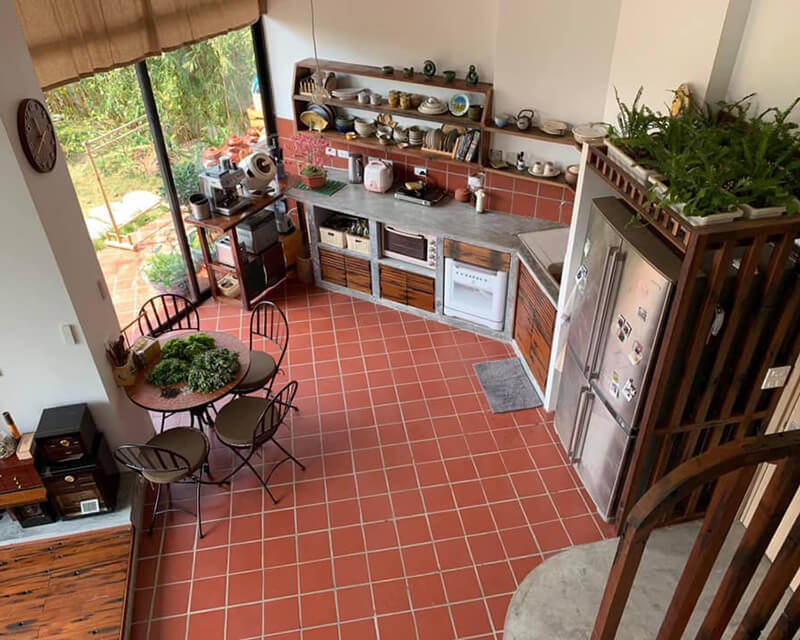 Go to the page with more information about Terracotta tiles Photo taken from above of an indoor kitchen with a terracotta tiled floor